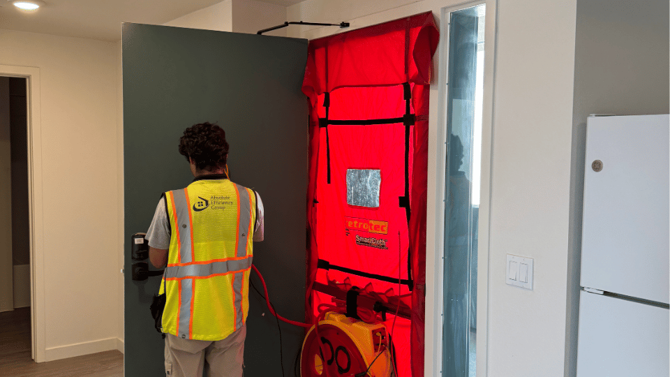 Photo of a technician performing enclosure, compartmentalization, or blower door test, a component of ECC or HERS verifications, at the Jordan Downs S5 multifamily project in Watts, CA. Services performed here include HVAC Air Balancing and ECC or HERS Testing for LEED certification.
